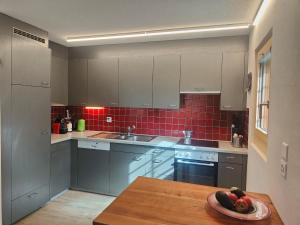 a kitchen with white cabinets and a plate of fruit on a table at Casa LeYu mitten in Ruschein in Ruschein +28 photos
