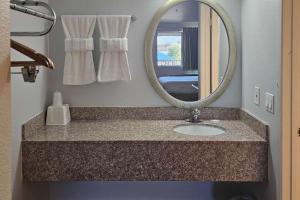a bathroom with a sink and a mirror at Rodeway Inn & Suites Thousand Palms - Rancho Mirage in Thousand Palms