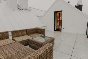 a living room with two wicker couches and a door at ApartView Porto Łeba by Rent like home in Łeba