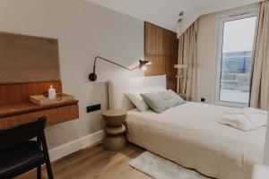 Schlafzimmer mit einem Bett, einem Schreibtisch und einem Fenster in der Unterkunft ApartView Porto Łeba by Rent like home in Łeba