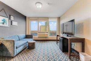 a living room with a blue couch and a television at Wyndham Fallsview Hotel in Niagara Falls