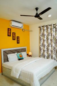 - une chambre avec un grand lit et un ventilateur de plafond dans l'établissement En Ocean Infinity Pool Villa Overlooking Sea ,Beach Touch, à Alibaug