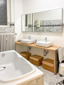 a bathroom with two sinks and a large tub at namastay! - Stilvoll mit Blick auf den Wasserturm in Mannheim