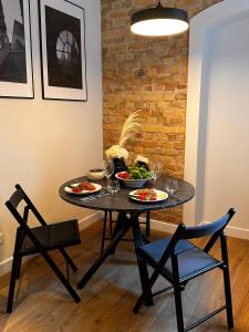einen Esstisch mit zwei Teller Essen drauf in der Unterkunft Stylish studio in the heart of Riga in Riga