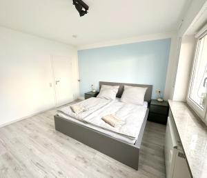 um quarto branco com uma cama com lençóis e almofadas brancos em Cozy Bamberg City Apartment em Bamberg