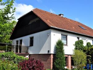 a white house with a red roof at Ferienwohnung Neubrandenburg-Broda - Ruhe und mehr in Neubrandenburg
