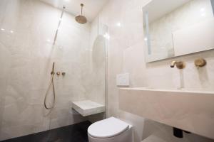 a white bathroom with a toilet and a sink at Luxury Flat - Opera & Upper Marais in Paris