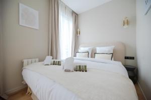 a large white bed in a room with a window at Luxury Flat - Opera & Upper Marais in Paris