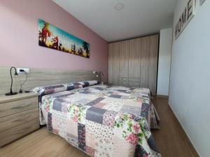 Un dormitorio con una cama con una colcha encima en PARÍS - LA COLINA, en San Miguel de Meruelo 11 fotos más