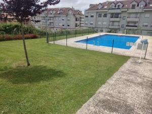 una piscina con un árbol en el césped en PARÍS - LA COLINA, en San Miguel de Meruelo