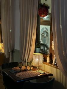 a dining room table with a lamp and a mirror at La Fontaine in Hunedoara