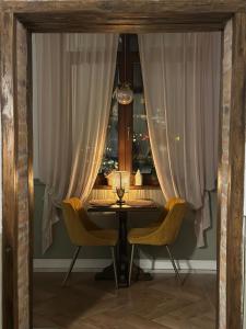- une table et deux chaises dans une chambre avec rideaux dans l'établissement La Fontaine, à Hunedoara
