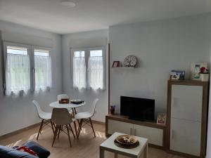 Una sala de estar con una mesa y un televisor. en PARÍS - LA COLINA, en San Miguel de Meruelo