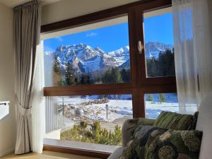 a room with a window with a view of mountains at SWEET Alps Apartment CCM in Madonna di Campiglio