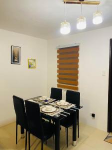 a dining room with a black table and chairs at Villa de Steph in San Pablo