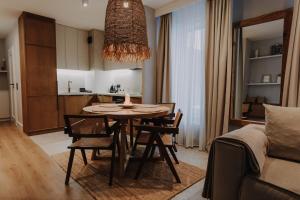 Una sala de estar con una mesa y sillas y un sofá. en ApartView Porto Łeba by Rent like home, en Łeba