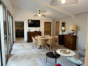 a living room with a table and chairs and a kitchen at Le mazet de fabrègues in Fabrègues
