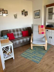 a living room with a couch and a chair at Ferienwohnung Stockrose in Middelhagen