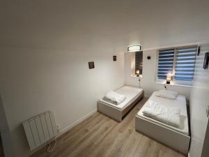 シェルブール・アン・コタンタンにあるLa Casa Tres - Cosy in the very centre portのベッド2台と窓が備わる小さな客室です。