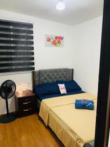 1 Schlafzimmer mit 2 Betten und einem Fenster mit einem Ventilator in der Unterkunft Villa de Steph in San Pablo City