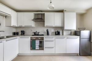 una cocina blanca con armarios y electrodomésticos blancos en Hatfield Uni - Free Parking - Business, Families, en Hatfield