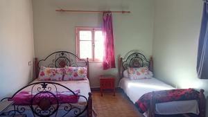 um quarto com 2 camas e uma janela em hôtel hicham em Uarzazate