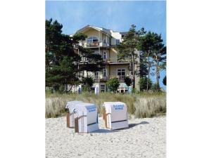 a group of beach chairs sitting on the sand in front of a house at Panorama-Meerblick in der Villa Atlantic mit Strandkorb am Strand in Binz