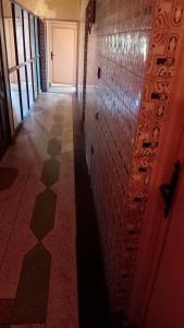 um corredor com uma parede de azulejos e uma porta em hôtel hicham em Uarzazate