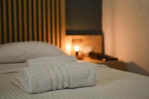 three towels are stacked on top of a bed at Hotel Plaza in Kalamata