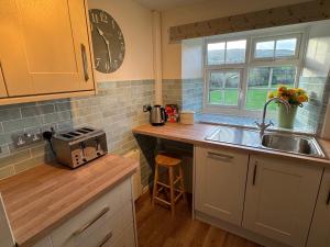 een keuken met een spoelbak en een aanrechtblad bij Wonderfully Scenic and Comfortable Dales Mill Property in West Burton