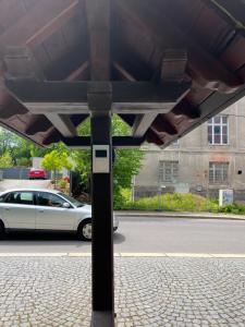 biały samochód zaparkowany po stronie ulicy w obiekcie Pension Parkschlösschen w mieście Lichtenstein