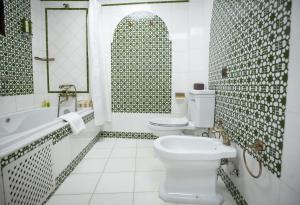 a bathroom with a toilet and a tub and a sink at La Llave de la Judería Hotel Boutique in Córdoba