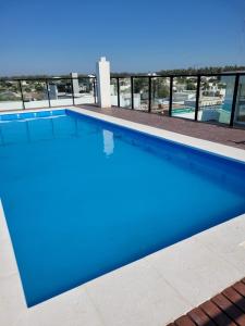 a blue swimming pool with a view of a building at Alquiler temporario AC 10 in Arroyito