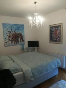 - une chambre avec un lit et un lustre dans l'établissement Eli's luxury apartment, à Zagreb