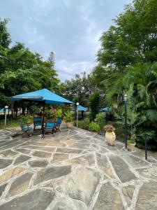 a stone patio with blue umbrellas and chairs at Maasai Koroga in Mombasa