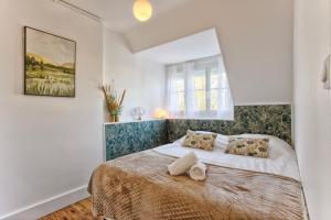 ein weißes Schlafzimmer mit einem großen Bett mit zwei Kissen in der Unterkunft La Casa Mathilda Elegant & soothing cocoon in Falaise