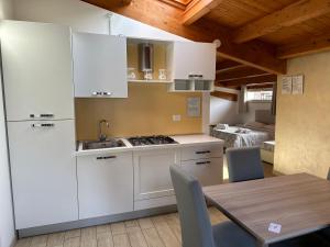 a kitchen with white cabinets and a table with chairs at B&B Le Mansarde in Pescara