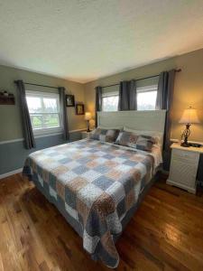 a bedroom with a bed with a checkered blanket at Bourbon Trail Cabin on the Farm in Lawrenceburg