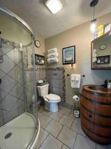 a bathroom with a toilet and a shower and a barrel at Bourbon Trail Cabin on the Farm in Lawrenceburg