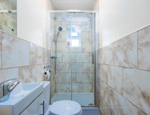 La salle de bains est pourvue d'une douche, de toilettes et d'un lavabo. dans l'établissement 4 Bed House With Driveway Parking, à Southampton