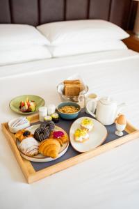 bandeja de alimentos para el desayuno en una cama en Courtyard by Marriott Hyderabad, en Hyderabad