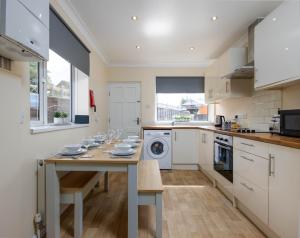 a kitchen with a table with dishes on it at 4 Bed House With Driveway Parking in Southampton