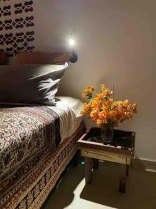 a bedroom with a bed and a table with a vase with flowers at Casa Brigita. Fortaleza in Fortaleza