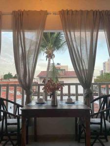 a table on a balcony with a palm tree at Casa Brigita. Fortaleza in Fortaleza