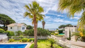 une villa avec une piscine et des palmiers dans l'établissement Costacabana - Villa Estrella, à Lloret de Mar