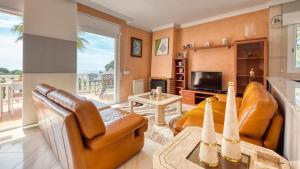 - un salon avec des meubles en cuir et une vue sur l'océan dans l'établissement Costacabana - Villa Estrella, à Lloret de Mar