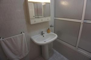 a white bathroom with a sink and a shower at !Your Home In Madeira in Funchal