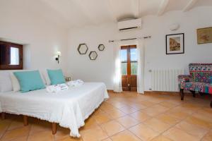 a bedroom with a white bed and a chair at Villa in San Jose sleeps 10 - Sa Vinya in Sant Josep de Sa Talaia