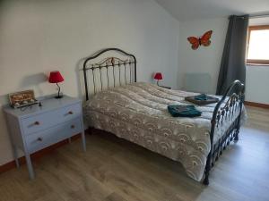 a bedroom with a bed and a dresser with butterflies on the wall at Le Papillon in Savigné