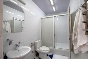 a bathroom with a toilet and a sink and a shower at Hotel Aquapark Alligator in Ternopilʼ
